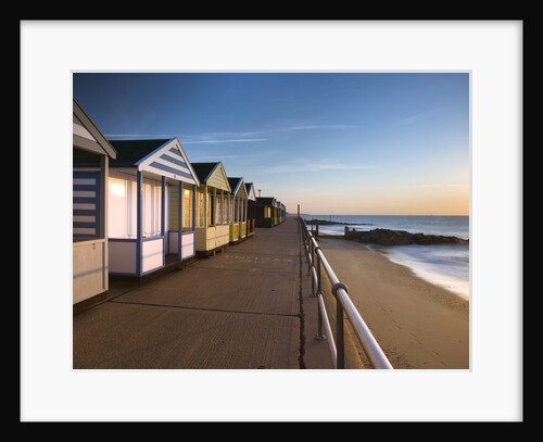 Beach huts in a row at sunrise by Assaf Frank